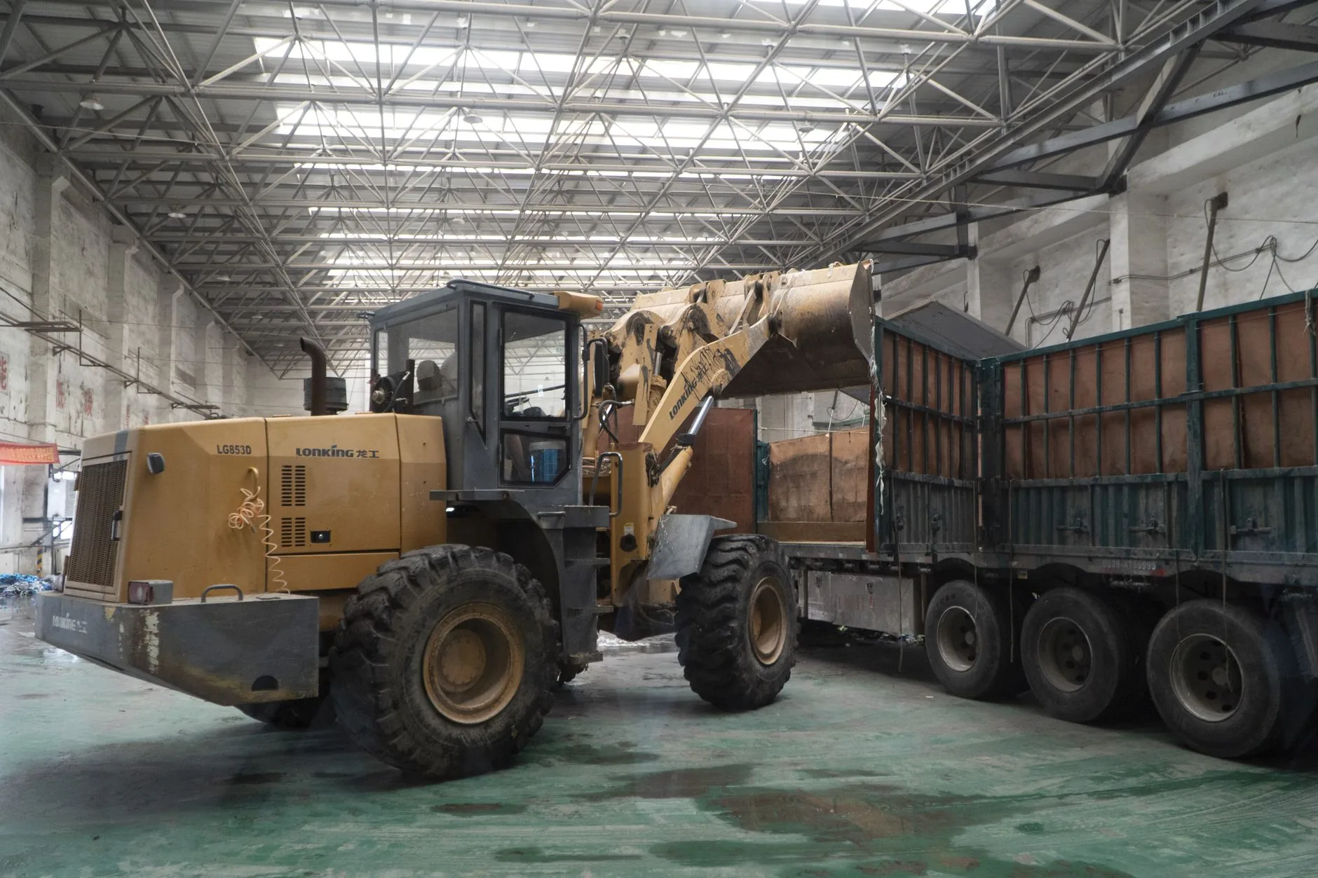 Front loader unloading a truck inside a warehouse