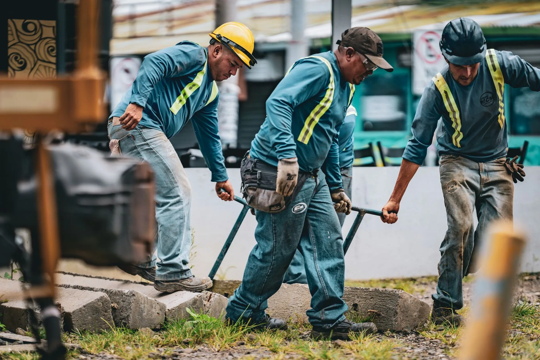 Labour hire crew in hi-vis lifting materials together on a construction site